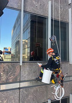 Person on the side of a building with rope access